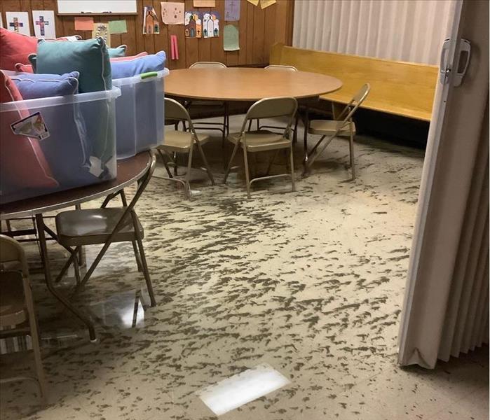 muddy debris on resilient tile flooring, round tables and chairs