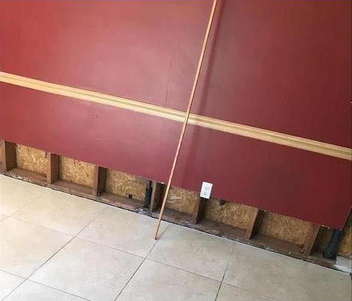 tile floor, red wall with lower area cut away showing wall void